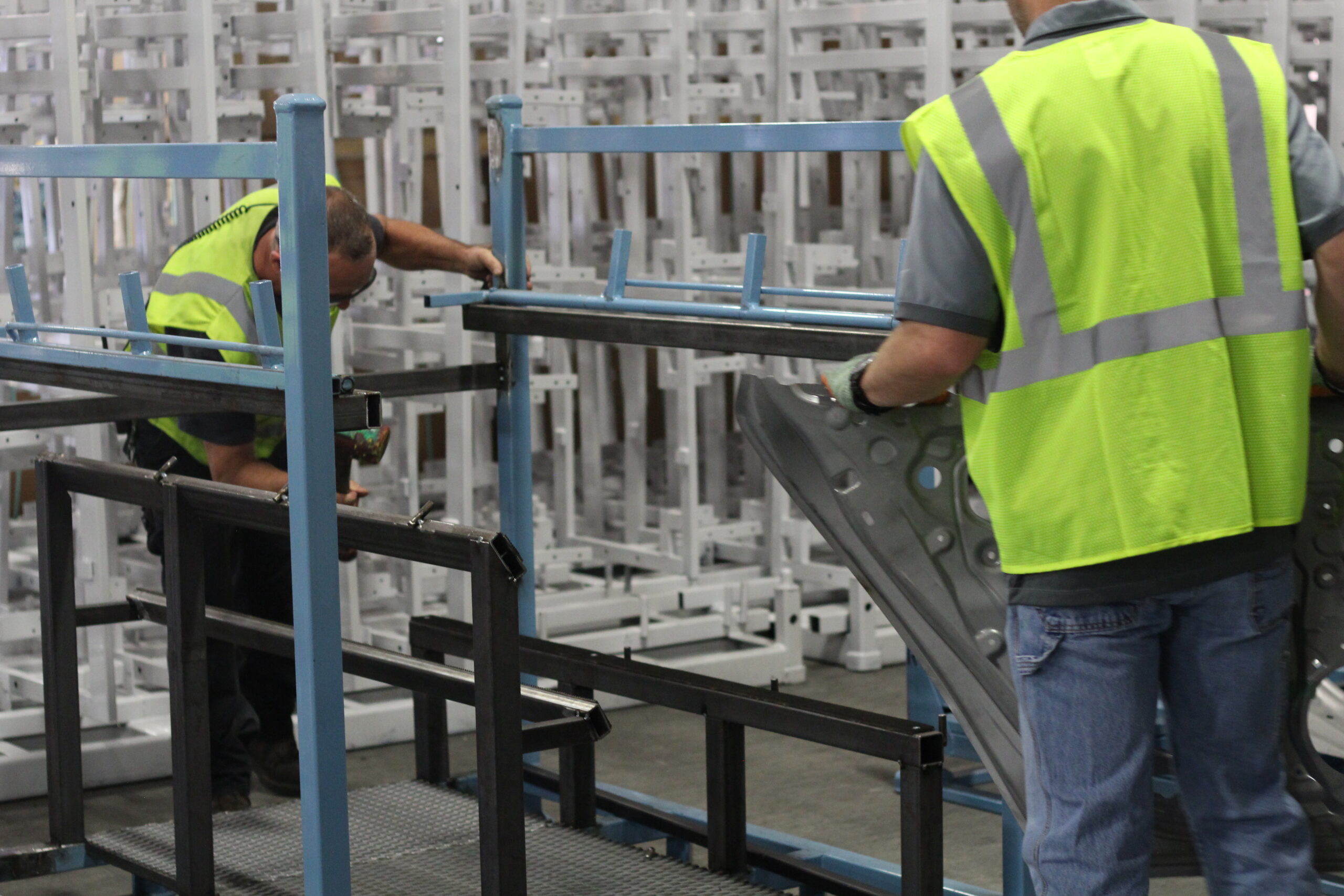 Quality control team inspecting automotive racks in the facility