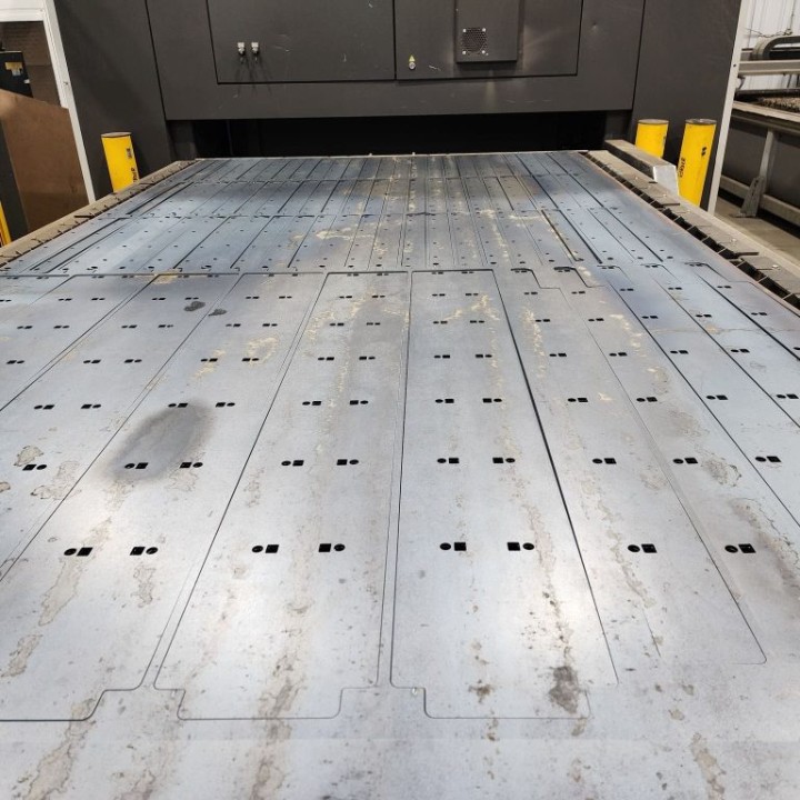 Sheet metal with laser-cut parts laid out on a cutting bed