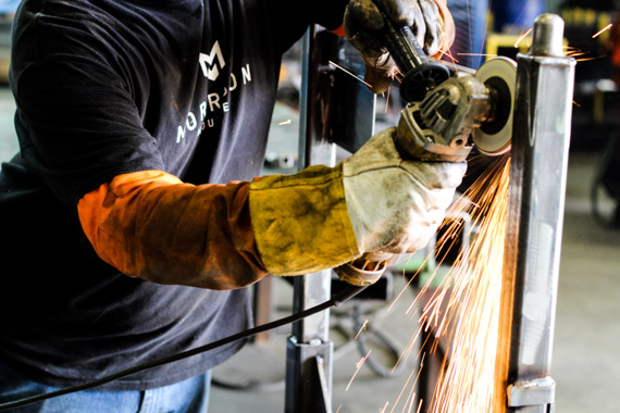 A worker grinding on a shipping rack
