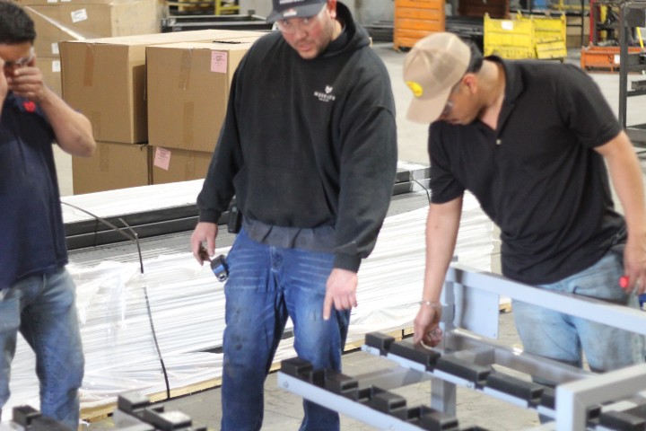 Quality control team reviewing a custom metal build on the shop floor before shipment.