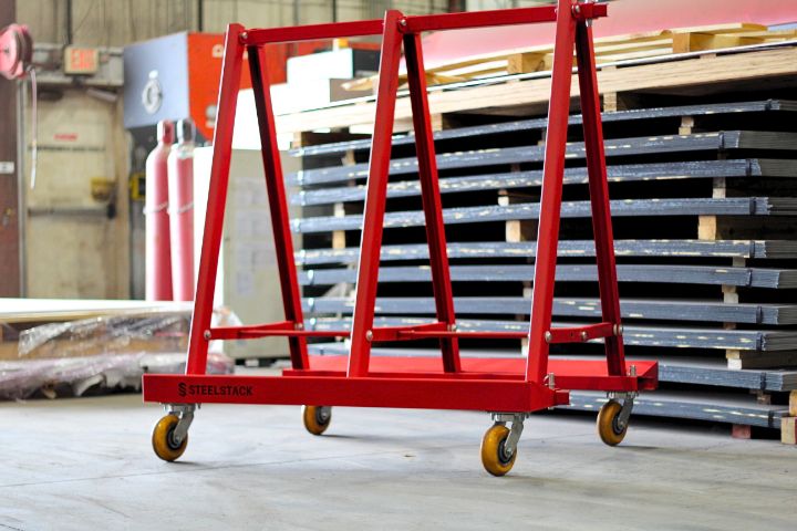 Red SteelStack A-frame material cart on swivel casters with stacked steel sheets in the background