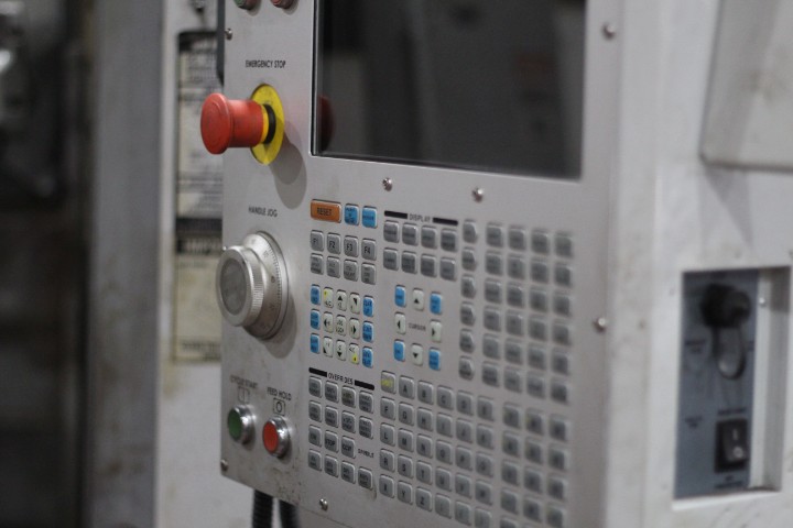 Close-up of a CNC machine operator panel with keypad and screen