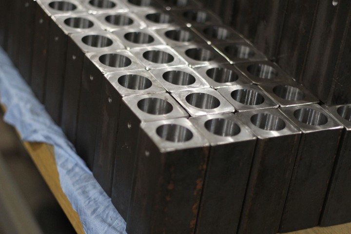 CNC-machined steel blocks lined up in rows