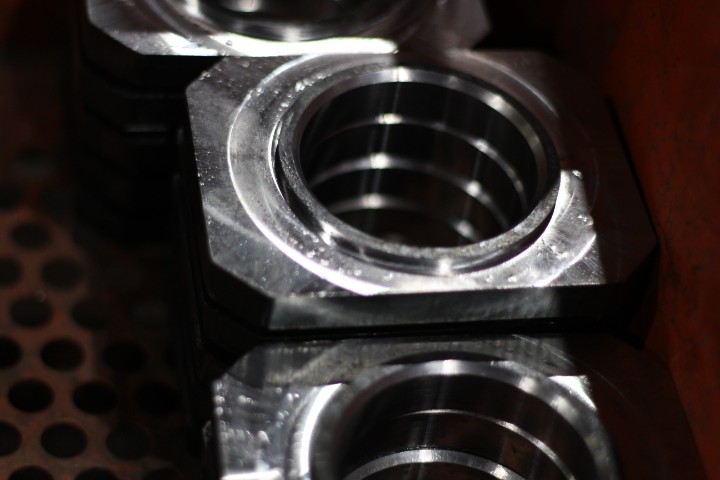 Close-up of CNC-machined steel parts with threaded holes