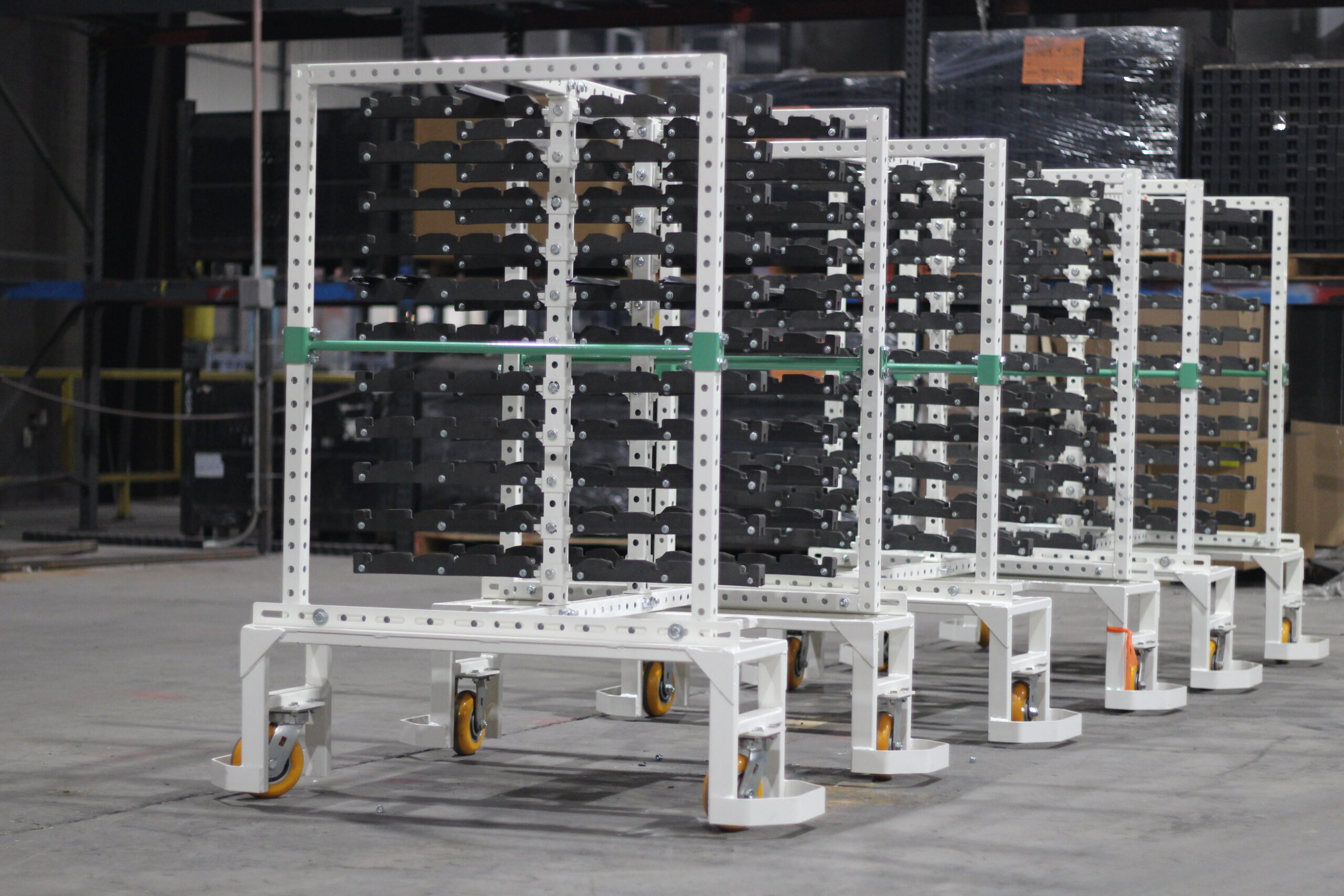Side view of white steel parts racks with built-in dunnage on casters