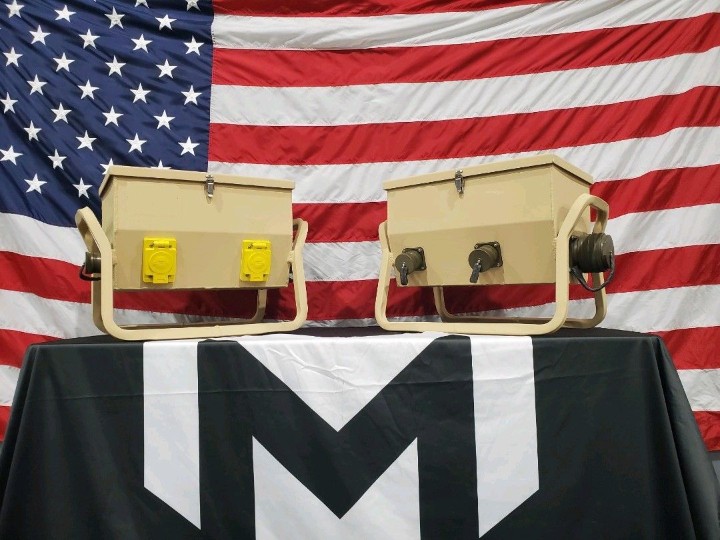 Production-ready fabricated enclosures displayed in front of an American flag