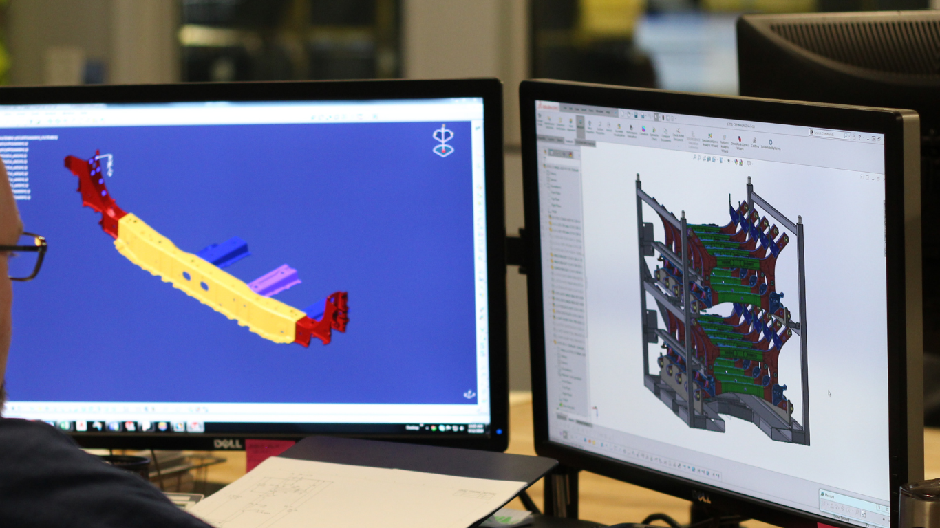 Engineer reviewing CAD models on dual monitors
