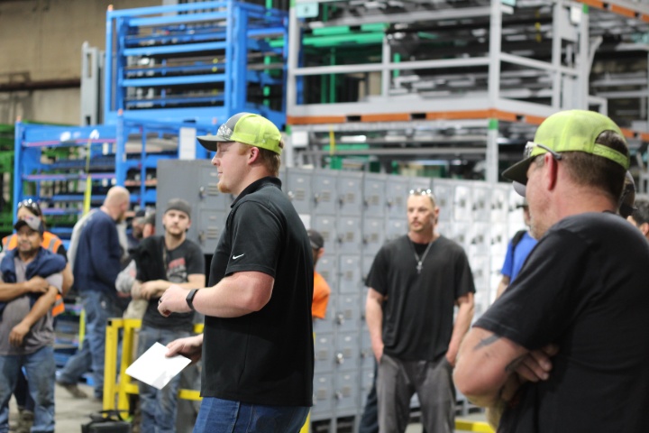 Group of workers gathered for a meeting on the shop floor