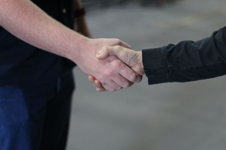 Two people shaking hands on the shop floor