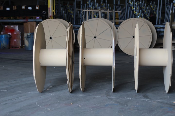 Tan-finished custom steel cable reels built for military and defense cable deployment programs.