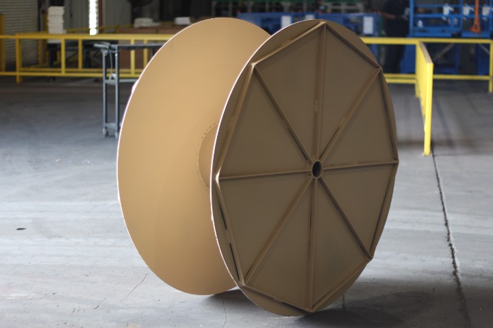 Tan-finished custom steel cable reel built for industrial wire and cable handling programs.
