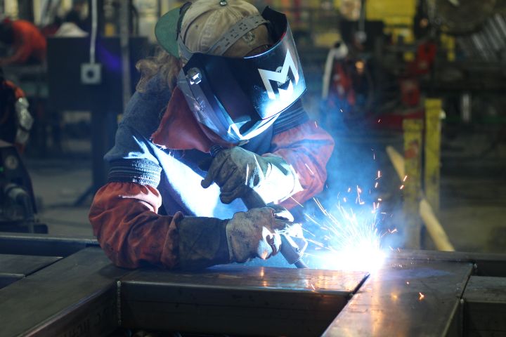 Welder fabricating a custom stack rack at Morrison Industries
